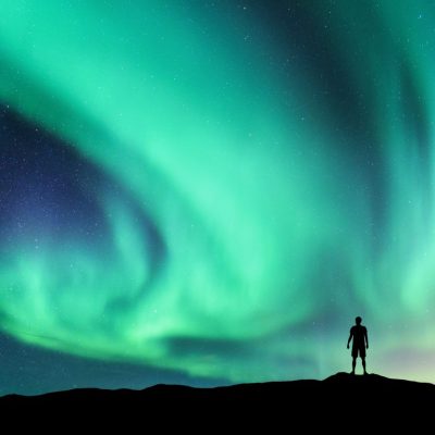 Silhouette of a Man Staring at Dancing Northern Lights