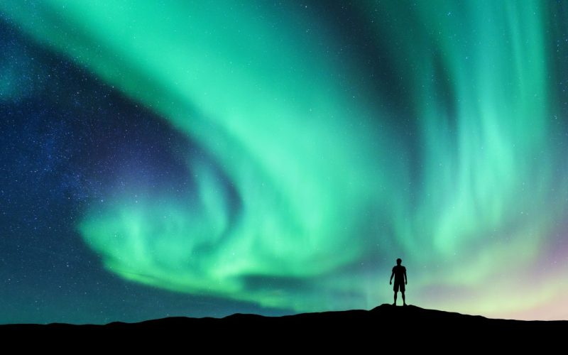 Silhouette of a Man Staring at Dancing Northern Lights