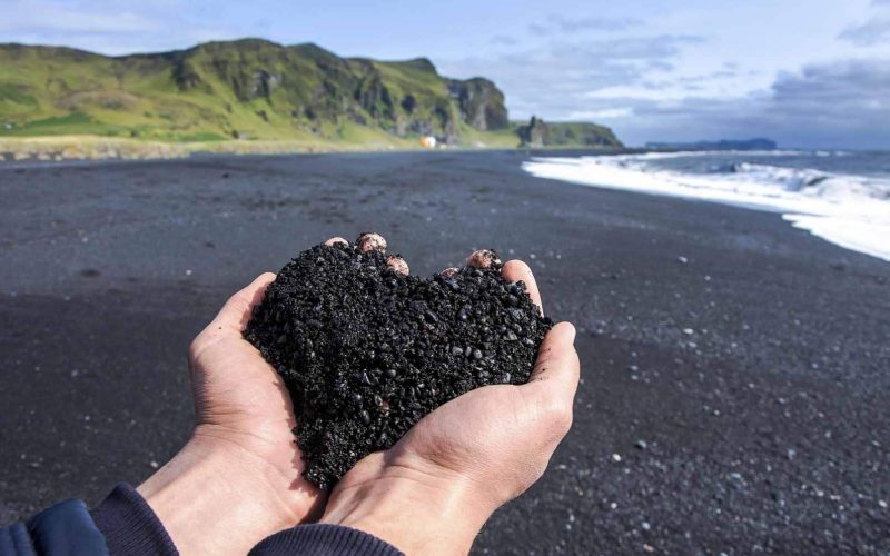 Man Holding Heart Shaped Black Sand on Reynisfjara Black Beach in South Iceland