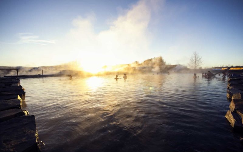 People Bathing in the Secret Lagoon During Winter Sunset in Fludir Iceland