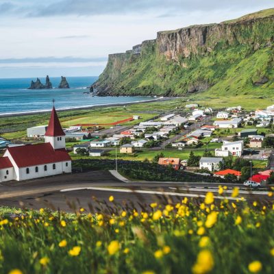 View Of Vík With The Wooden Church And The Sea Stack