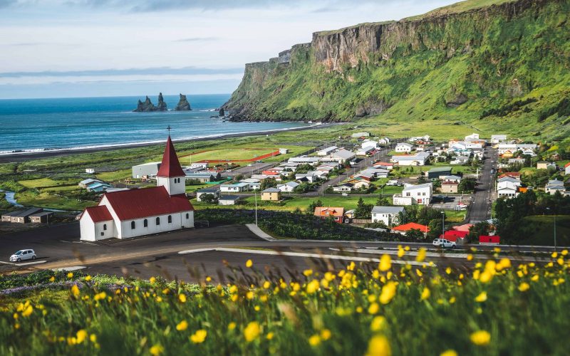 View Of Vík With The Wooden Church And The Sea Stack